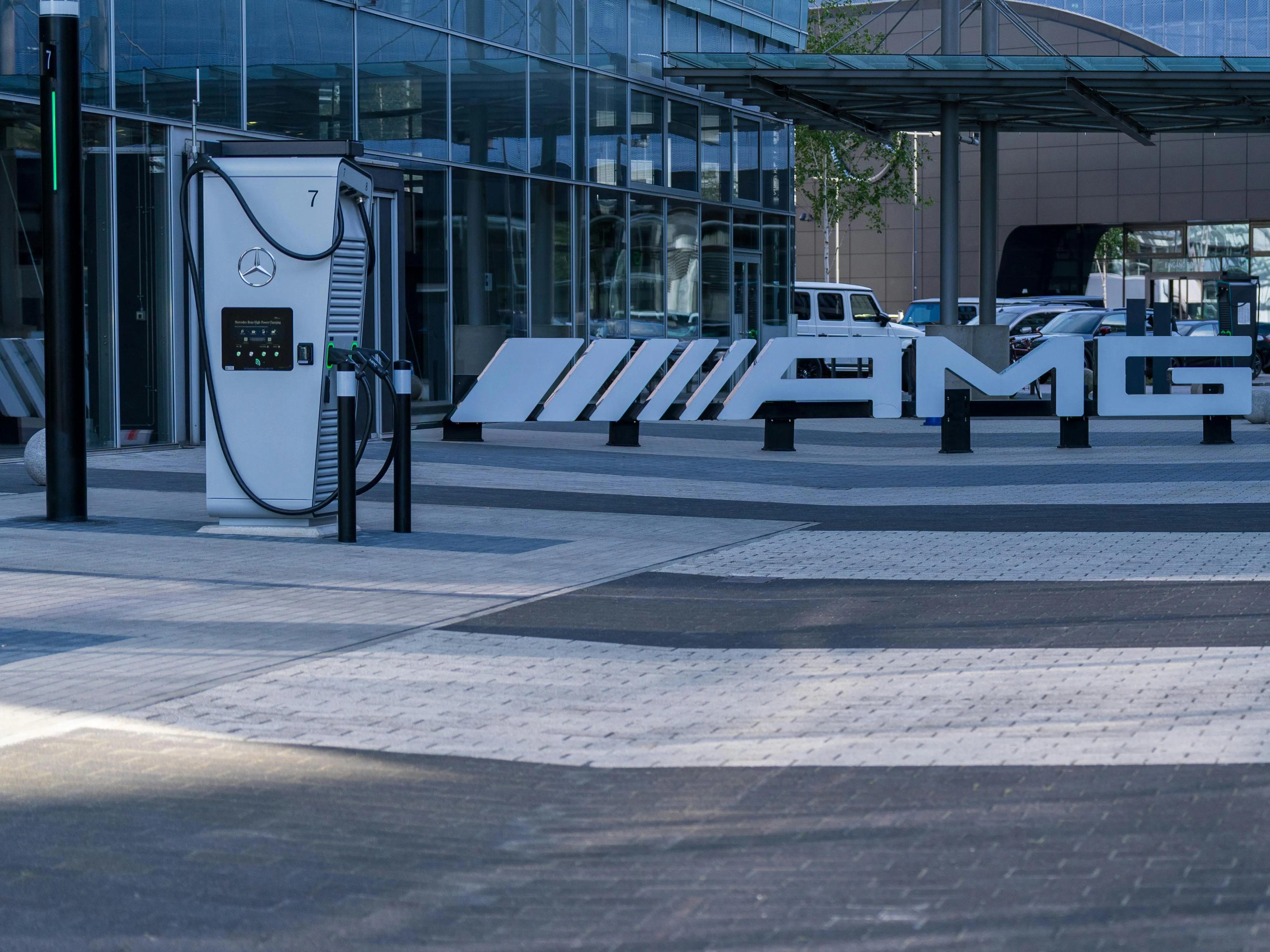 Ein modernes Elektroauto wird an einer Ladestation in einem urbanen, grünen Umfeld geladen, was das nachhaltige Investment in Ladeinfrastruktur-Aktien symbolisiert.
